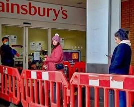 Social distancing while lining up at a supermarket. Credit: Philafrenzy/Wikimedia Commons