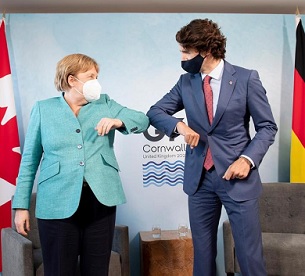 Canadian Prime Minister Justin Trudeau welcomes German Chancellor Angela Merkel at the start of a G7 bilateral meeting. Credit - Associated Press