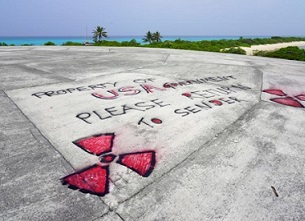 Graffiti in May 2018 is written on Runit Dome, in Enewetak Atoll of the Marshall Islands, urging the United States to take responsibility for the radioactive waste encapsulated inside the concrete structure. (Mika Makelainen / Yle)