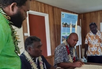 Minister Togamana signing the certificate of declaration flanked by staff of the Environmental Division MECDM and a Community elder.