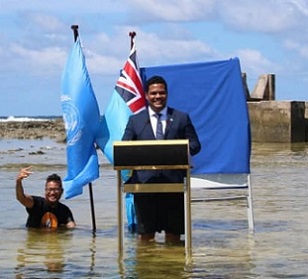 Tuvalu’s Minister for Justice, Communication & Foreign Affairs Simon Kofe gives a COP26 statement while standing in the ocean in Funafuti, Tuvalu November 5, 2021. Tuvalu Foreign Ministry | via Reuters