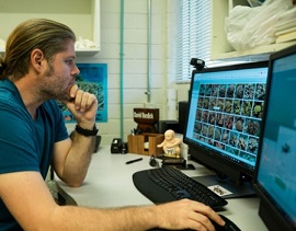 David Burdick, a research associate at the University of Guam Marine Laboratory, looks through the online database of the UOG Biorepository. (UNIVERSITY OF GUAM)