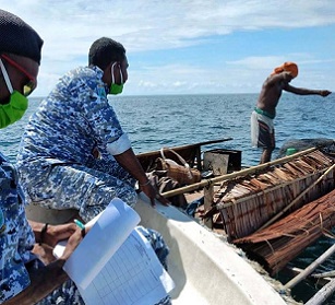 Patrolmen document a violation in a marine reserve in West Papua. Image: Syafri Tuharea, UTPD