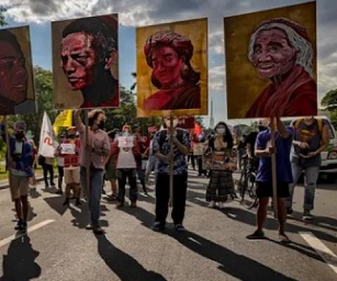 Climate activists hold up portraits of slain Philippine environmental defenders during a climate justice protest last November. Photograph: Ezra Acayan/Getty Images