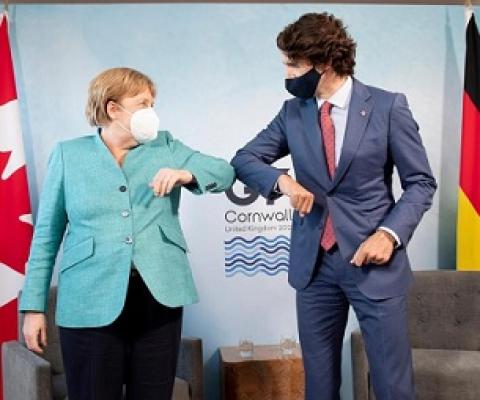 Canadian Prime Minister Justin Trudeau welcomes German Chancellor Angela Merkel at the start of a G7 bilateral meeting. Credit - Associated Press