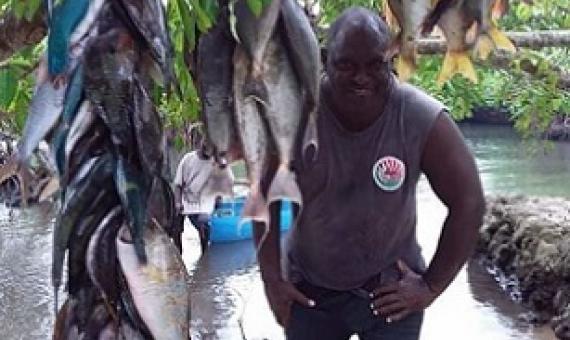 Authorised offier, Mr. John Laket, with some of the fishes landed on Chiefs day. Credit - Glenda Wille, https://dailypost.vu/