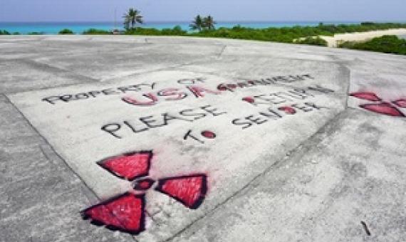 Graffiti in May 2018 is written on Runit Dome, in Enewetak Atoll of the Marshall Islands, urging the United States to take responsibility for the radioactive waste encapsulated inside the concrete structure. (Mika Makelainen / Yle)